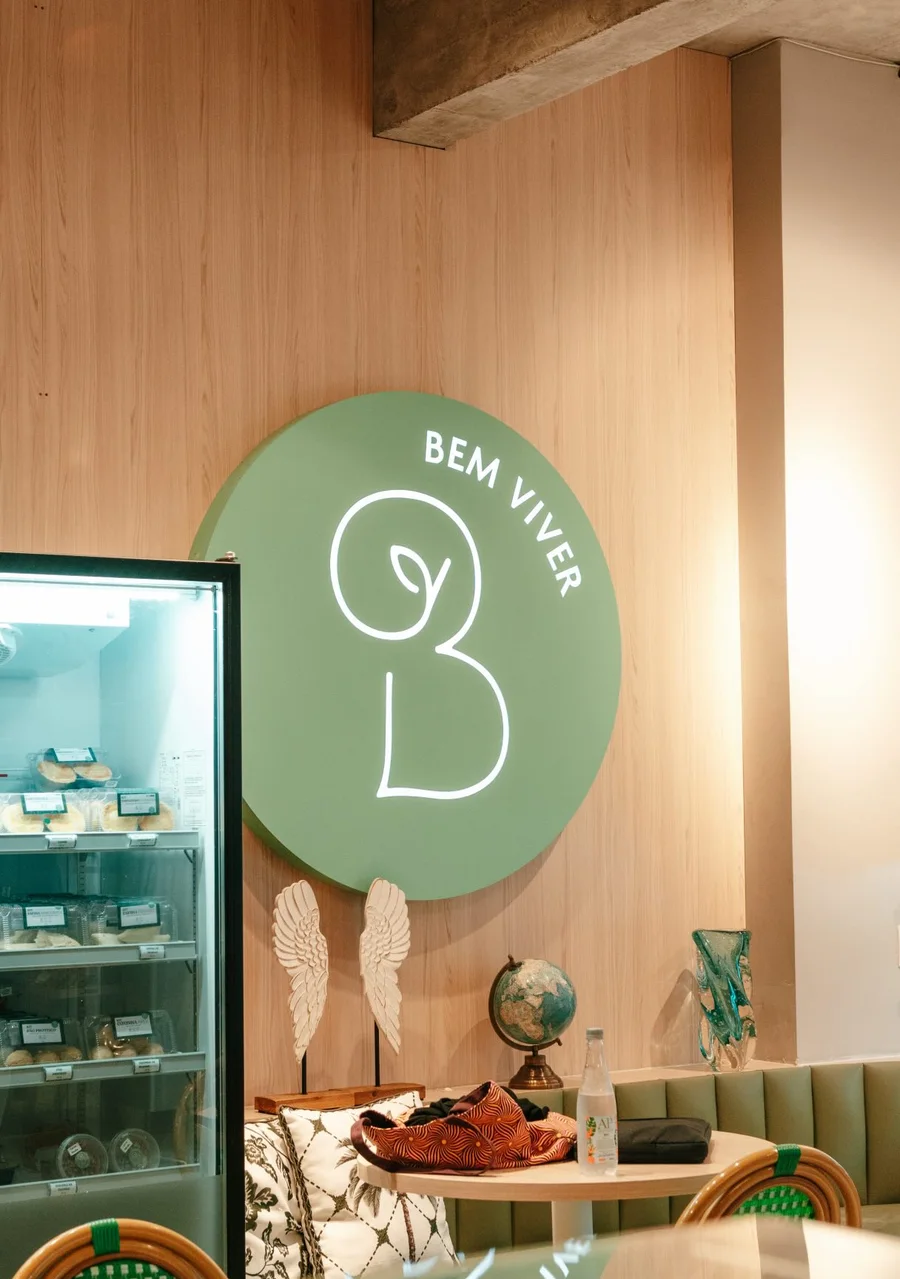 Salão da Bem Viver Café em Balneário Camboriú, com o logotipo verde na parede e a vitrine refrigerada